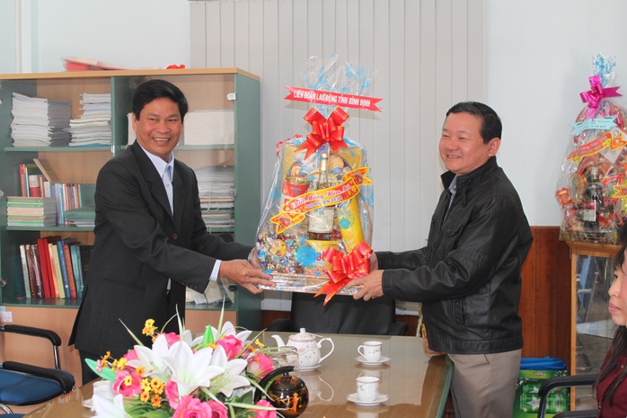 Ông Huỳnh Thanh Xuân, Chủ tịch LĐLĐ tỉnh Bình Định (bìa trái), tặng quà Tết cho đại diện Công ty Môi trường Đô thị Quy Nhơn     ẢNH: ANH TÚ