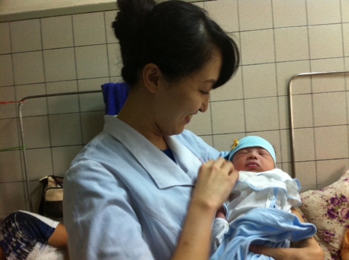 Điều dưỡng người Nhật Bản Mika thăm bệnh nhi được cô đỡ đẻ trong quá trình người mẹ chuyển dạ
