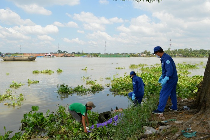 Nhân viên Công ty Vệ Sinh Môi trường TP HCM đưa thi thể bé gái về nhà xác phục vụ công tác điều tra