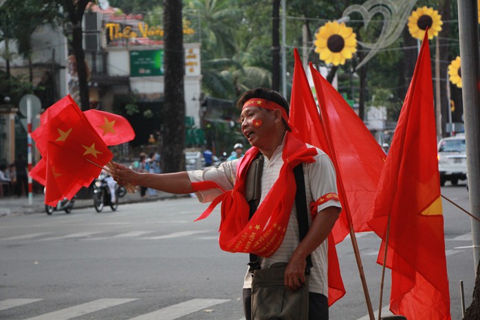  Một người bán cờ và băng rôn trên đường Phạm Ngọc Thạch.