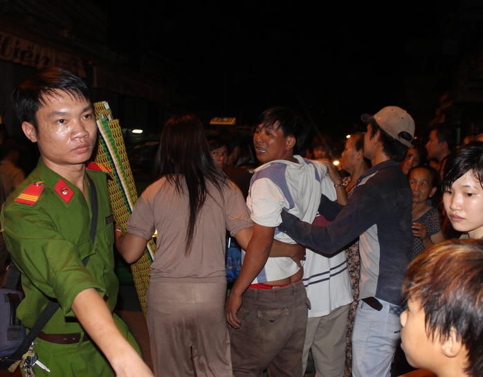 Anh Phạm Văn Lực (giữa) khóc nức nở trong vòng tay người nhà sai khi biết con mình chếti 