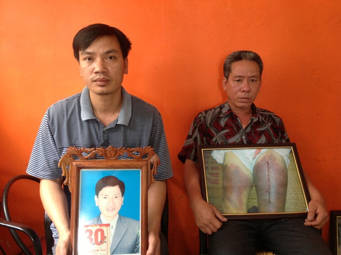 Người nhà bên di ảnh và ảnh chụp những vết thương của nạn nhân Nguyễn Mậu Thuận