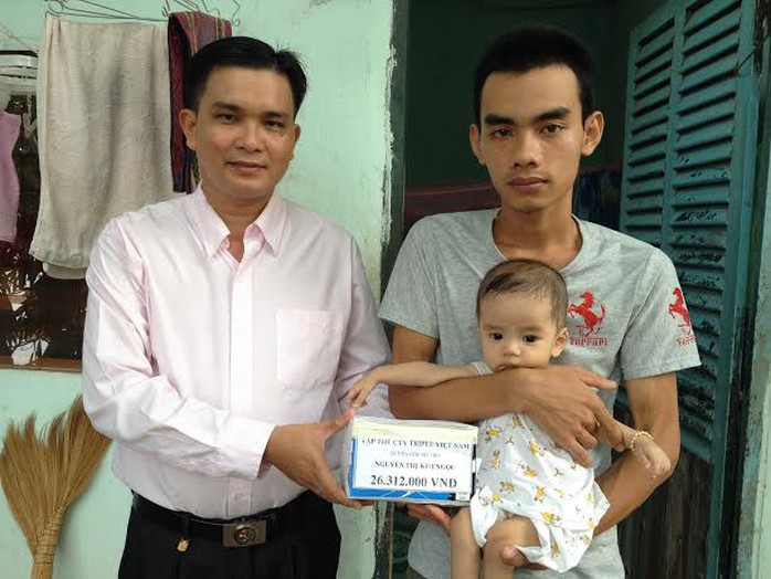 Ông Lê Trần Thanh Hải, Chủ tịch CĐ Công ty Triple Việt Nam, trao tiền hỗ trợ cho gia đình cháu Nguyễn Gia Bảo