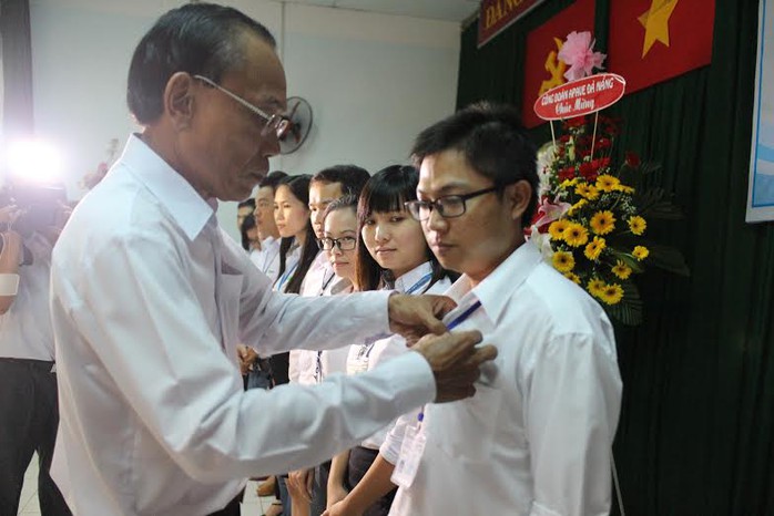 Ông Lương Văn Hồng, Chủ tịch LĐLĐ quận 3, TP HCM, gắn huy hiệu Công đoàn cho đoàn viên Công ty TNHH Apave