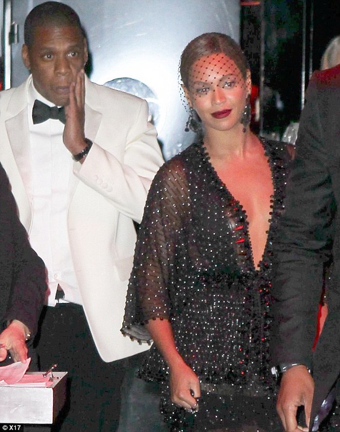 Jay Z tay ôm mặt khi rời khỏi khách sạn, trong khi Beyoncé nở nụ cười xã giao. Ảnh: X17