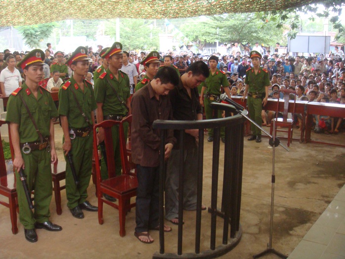 Bị cáo Đinh Văn Chuyên (bên trái) và Đoàn Quang Lập tại phiên tòa lưu động sáng 6-6, tổ chức xử tại UBND xã Tiến Hưng, thị xã Đồng Xoài, tỉnh Bình Phước. Chuyên bị tuyên tử hình, còn Lập chỉ bị 12 tháng tù.