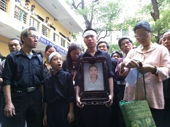 Người nhà mang theo di ảnh của nạn nhân Lê Thị Thanh Huyền tại phiên xét xử ngày 14-4