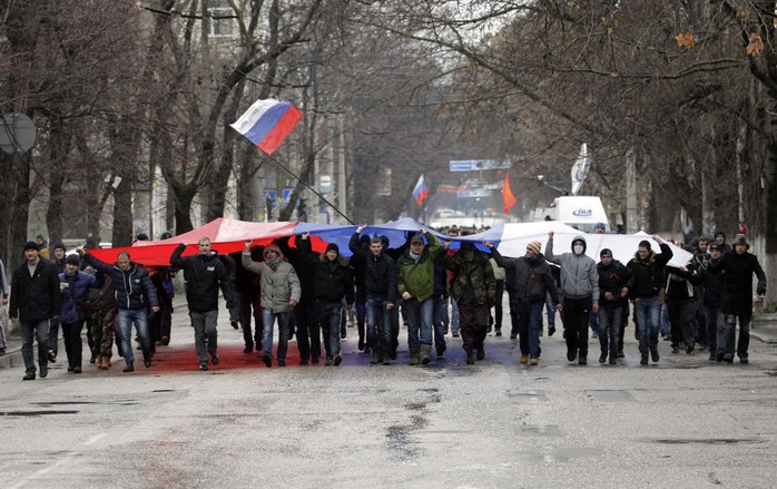 Người biểu tình thân Moscow kéo cờ Nga tuần hành ở Symferopol ngày 27-2. Ảnh: AP