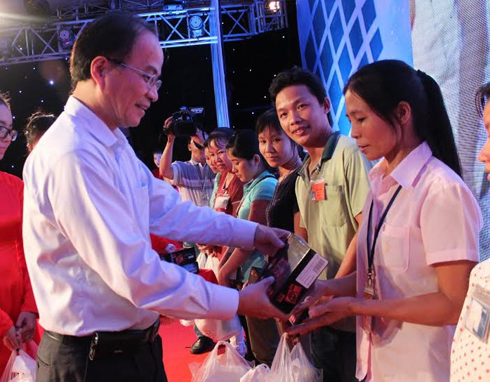 Ông Lê Mạnh Hà, Phó chủ tịch UBND TP HCM, trao radio cho CN ở trọ tại quận Thủ Đức   Ảnh: THANH NGA