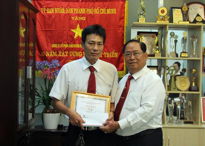Ông Tạ Long Hỷ, Phó Tổng giám đốc Vinasun (bìa trái), trao giấy khen và tiền thưởng cho tài xế Bùi Vinh Hiển