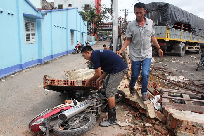 Hia chiếc xe máy bị tường đổ đè làm hư hỏng