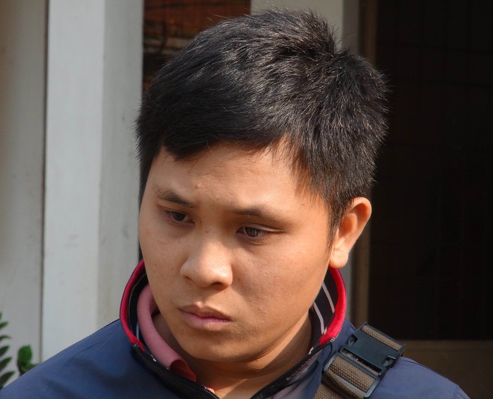 Hoàng Văn Bình, đối tượng chở thuốc lá lậu ngụy trang trong đống trấu, đang bị công an tạm giữ.
