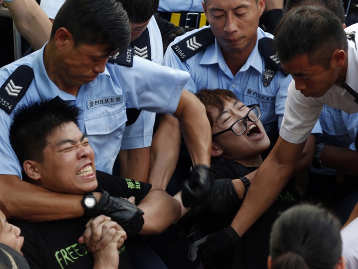 Cảnh sát tìm cách khống chế người biểu tình ngồi ở Hồng Kông hôm 2-7. Ảnh: AP
