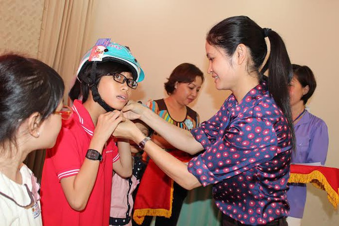 Bà Nguyễn Thu Hương, Chủ tịch LĐLĐ quận Bình Thạnh, TP HCM, tặng nón bảo hiểm cho con CNVC-LĐ khó khăn