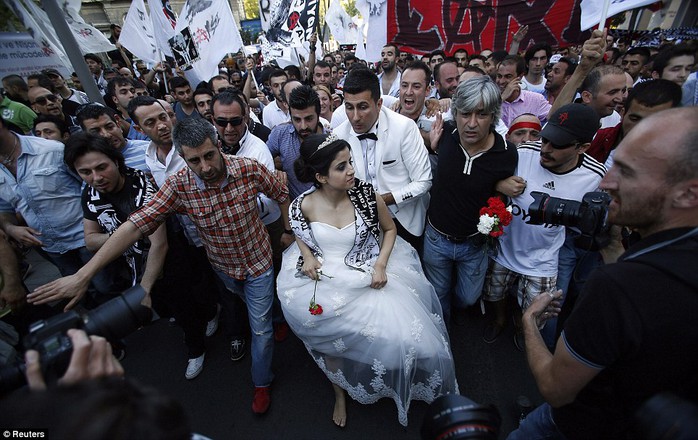 A newlywed couple joins protesters as they march towards Taksim Square in Istanbul June 8, 2013