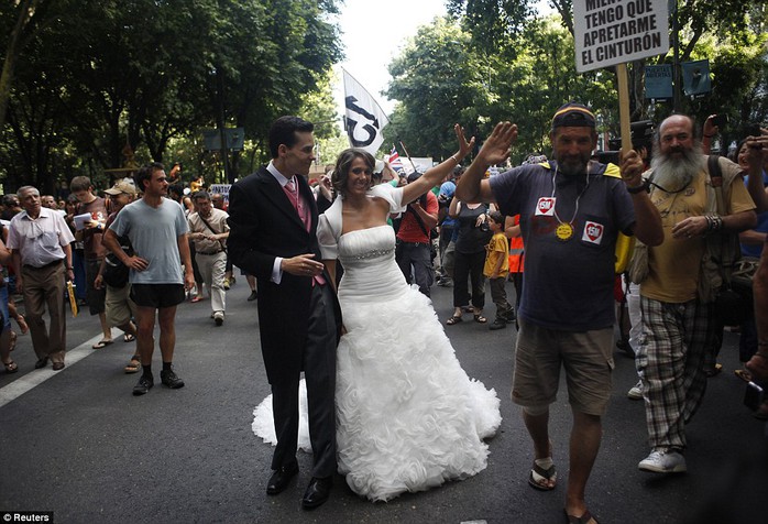 Spanish newlyweds join demonstrators as they march towards Madrid's Puerta del Sol during a protest against politicians, banks, the economic crisis and austerity measures of Europe, in Madrid July 24, 2011