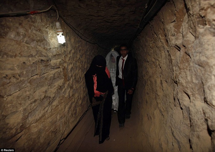 Palestinian groom Emad al-Malalha, 21, walks with Manal Abu Shanar, 17, his Egyptian bride inside a smuggling tunnel beneath the Gaza-Egypt border in the southern Gaza Strip on March 21, 2013