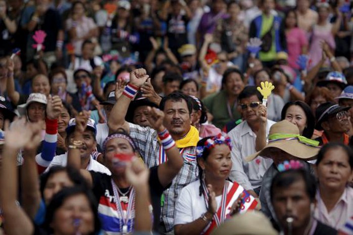 Anti-government protesters react as they listen to a leaders speech at an intersection protesters are occupying in downtown Bangkok February 8, 2014. REUTERS/Damir Sagolj