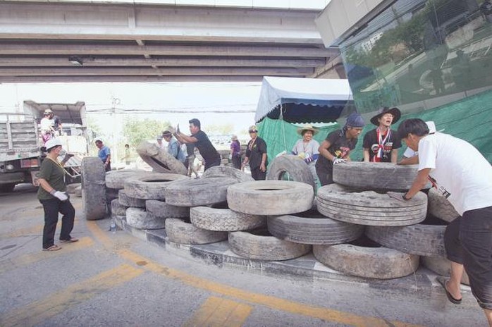 Protesters place car tyres to block a section of Chaeng Wattana Road to prevent motorists from passing through the rally site.