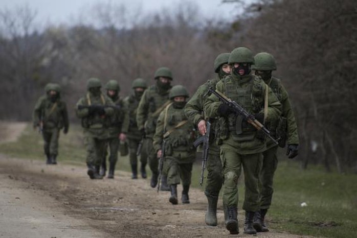 Armed men, believed to be a Russian servicemen, walk as they change shifts near a military base in Perevalnoye, near the Crimean city of Simferopol, March 20, 2014. REUTERS/Baz Ratner