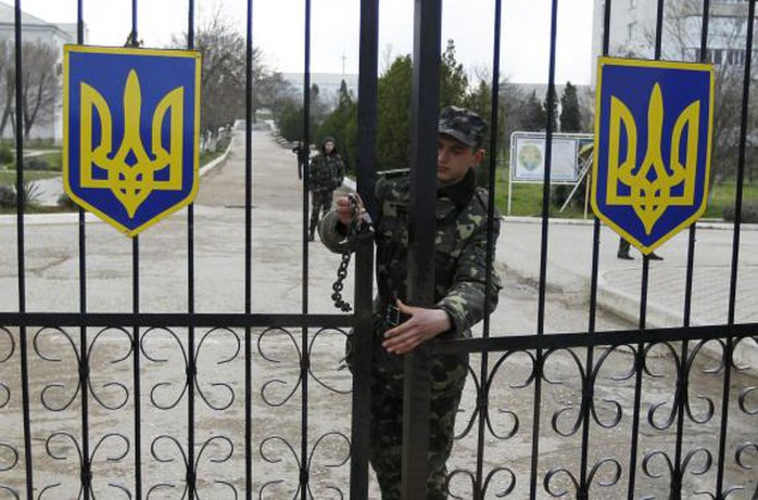 A Ukrainian soldier closes an entrance gate at the airforce base in the Crimean town of Belbek March 20, 2014. REUTERS-Shamil Zhumatov