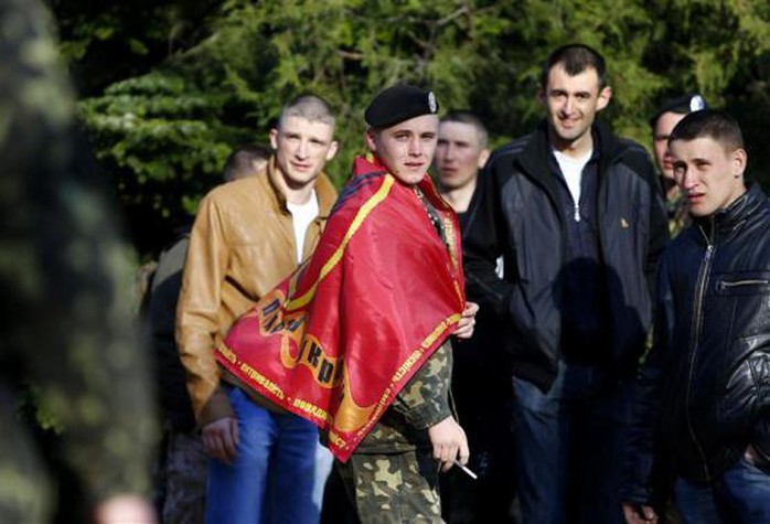 A Ukrainian marine wearing a regimental flag waits to depart Crimea, outside a Ukrainian military base in the Crimean port city of Feodosia, March 24, 2014. REUTERS-Shamil Zhumatov