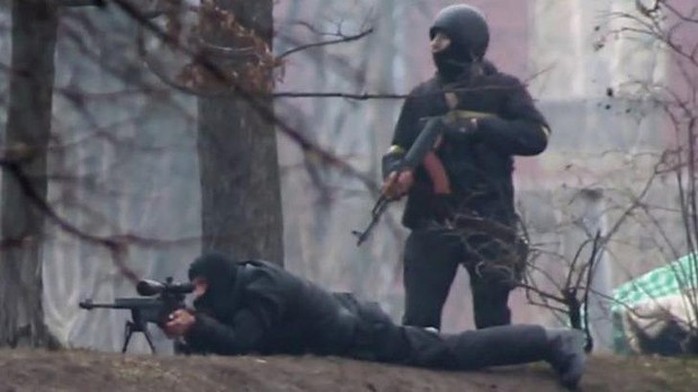 In cold blood: A riot policeman is seen standing next to a sniper in Kiev on February 20.