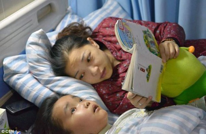 Tragic: Zhou Lu, 34, reads to her terminally ill son Chen Xiatian, seven, who went blind with brain cancer