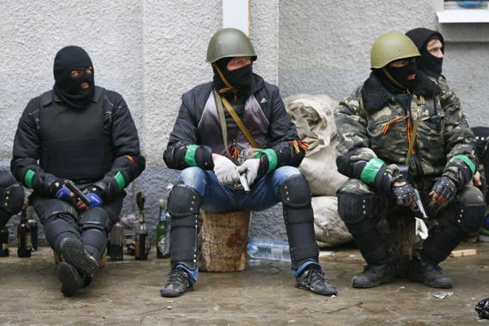 Pro-Russian armed men sit near the police headquarters in Slaviansk April 13, 2014. Ukraines Interior Minister on Sunday told residents in the eastern city of Slaviansk to stay indoors, in anticipation of clashes between pro-Russian militants who have seized official buildings and Ukrainian security forces. REUTERS-Gleb Garanich