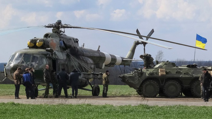 Ukrainian soldiers are seen near a MI-8 military helicopter and armored personnel carrier at a checkpoint near the town of Izium in Eastern Ukraine, April 15, 2014. (Reuters / Dmitry Madorsky) 