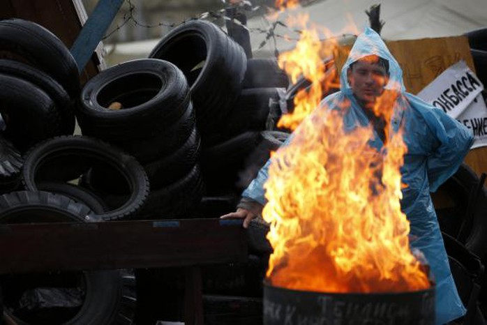 A pro-Russia protester warms himself by the fire on a barricade outside a regional government building in Donetsk, in eastern Ukraine April 20, 2014. REUTERS-Marko Djurica