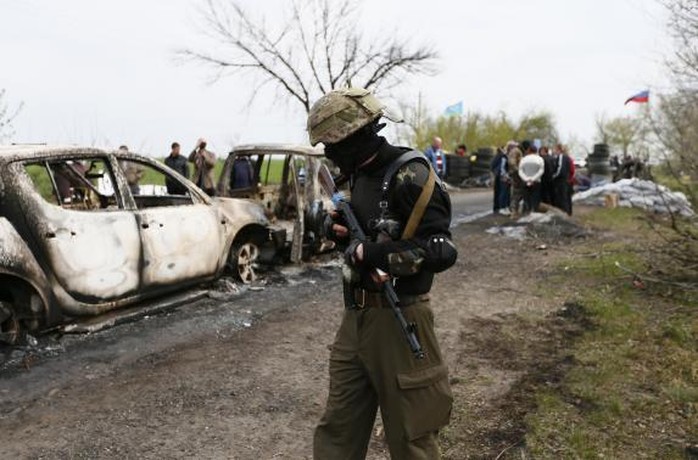 A Pro-Russian militant walks near a checkpoint that was the scene of a gunfight overnight near the city of Slaviansk, April 20, 2014. REUTERS-Gleb Garanich