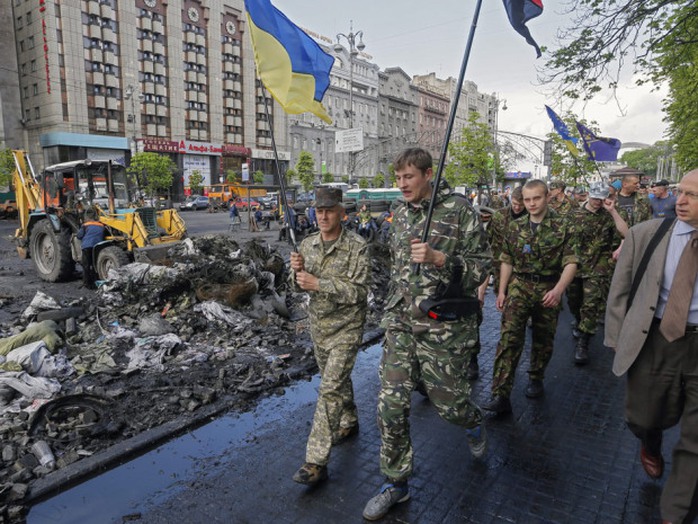 Maydans self-defence members march as Ukrainian communal workers remove a barricade near Independence Square in Kyiv Wednesday.
