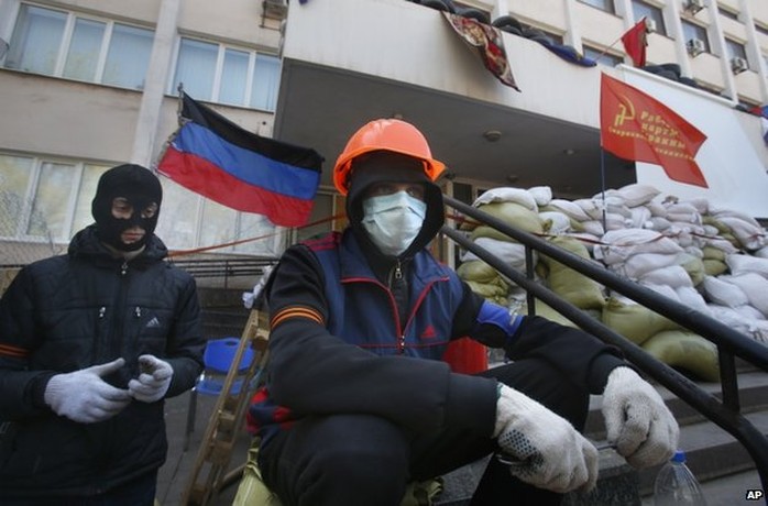 Masked pro-Russian protesters guard a barricade in front of the city hall in Mariupol, Ukraine, 17 April