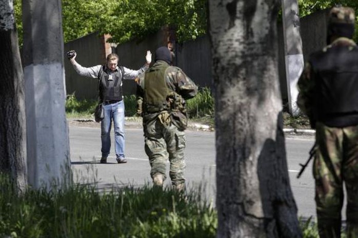 Pro-Russian armed separatists check a journalist at gunpoint in Donetsk May 6, 2014.  REUTERS/Konstantin Chernichkin