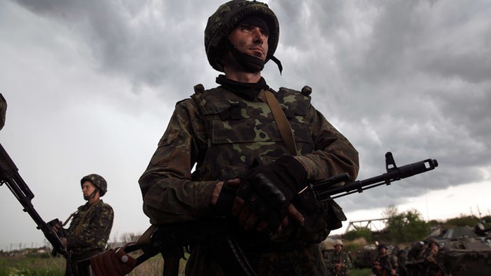 A Ukrainian soldier stands in front of Pro-Russian Civilians at a checkpoint near the town of Slaviansk in eastern Ukraine.(Reuters / Baz Ratner)