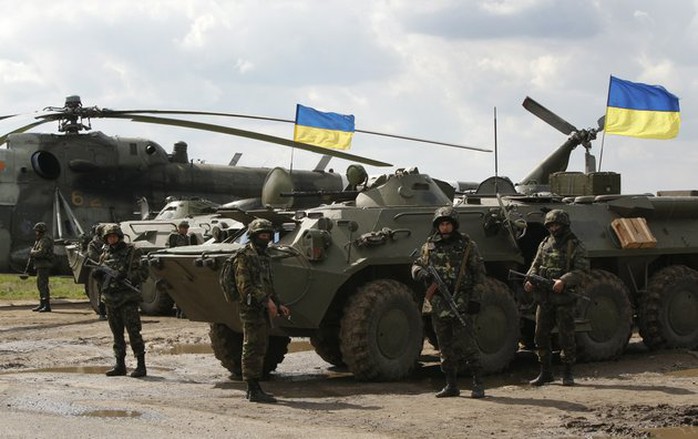 ukrainian-soldiers-stand-at-armored-personnel-carriers-with-ukrainian-flags-in-the-back-as-ukrainian-army-troops-receive-ammunition-in-a-field-on-the-outskirts-of-izyum-eastern-ukraine-on-tuesday-april-15-2014-an-associated-press-reporter-saw-at-least-14-armored-personnel-carriers-with-ukrainian-flags-one-helicopter-and-military-trucks-parked-24-miles-north-of-the-city-tuesday