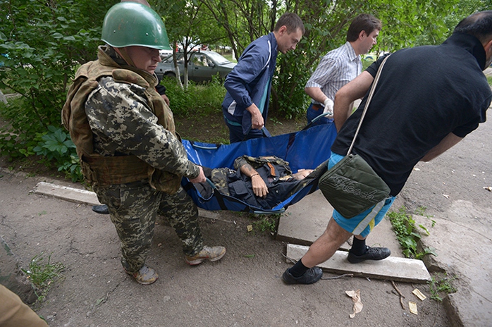 A fighter of the peoples militia and local residents evacuate a militiaman wounded during a battle with Ukraines border guards in the Mirny neighborhood on the outskirts of Lugansk (RIA Novosti / Evgeny Biyatov)