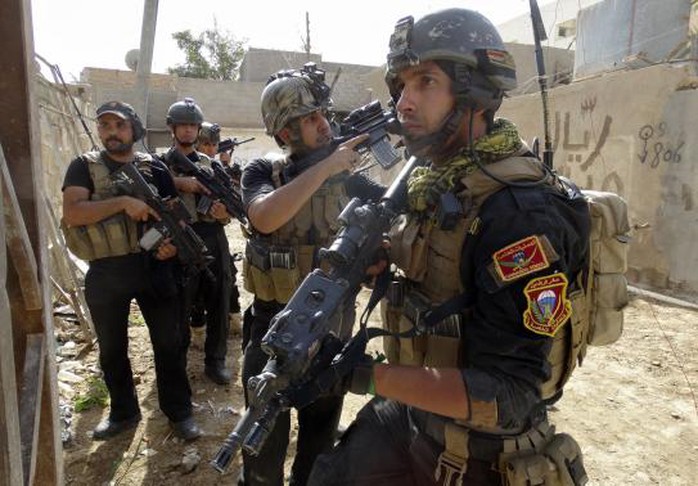 Members of the Iraqi Special Operations Forces (ISOF) take their positions during a patrol looking for militants of the Islamic State of Iraq and the Levant (ISIL), explosives and weapons in a neighbourhood in Ramadi, June 13, 2014. Picture taken June 13, 2014. REUTERS-Osama Al-dulaimi