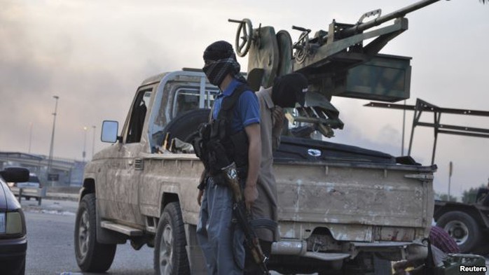 Fighters of the Islamic State of Iraq and the Levant (ISIL) stand guard at a checkpoint in the northern Iraq city of Mosul, June 11, 2014.