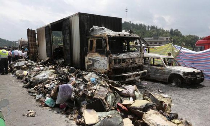 Debris is seen next to burnt vehicles after an explosion and a fire following a traffic accident, at a section of the Hukun (Shanghai to Kunming) highway in Shaoyang, Hunan province July 19, 2014. REUTERS/China Daily