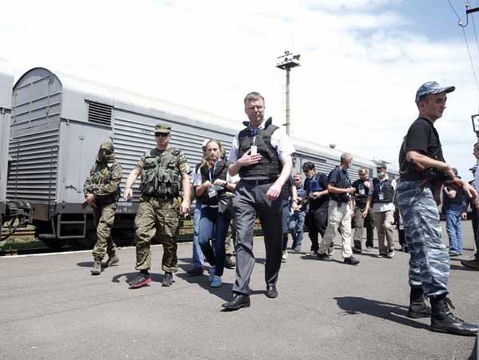 Các quan sát viên Tổ chức An ninh và Hợp tác châu Âu (OSCE) ở gần các toa xe chứa nạn nhân. Ảnh: REUTERS