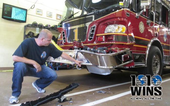 New Hyde Park Fire Chief Steven Waldron shows damage to fire truck from crash. (Photo: Mona Rivera, 1010 WINS)