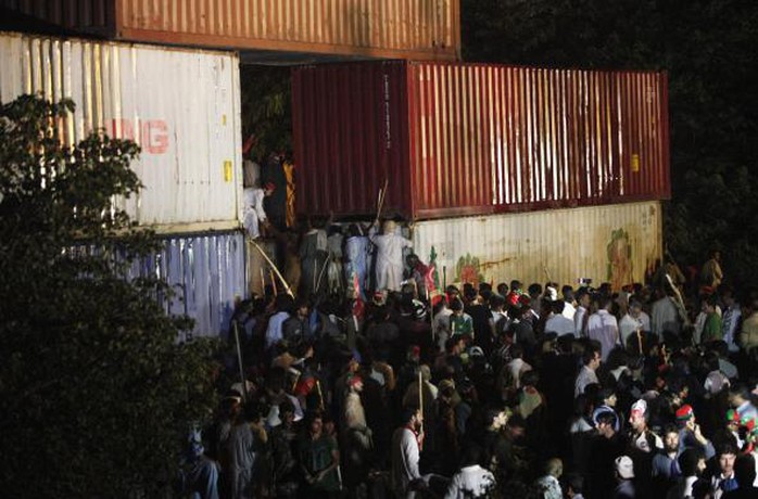 Supporters of former international cricketer Imran Khan, chairman of the Pakistan Tehreek-e-Insaf (PTI) political party, climb on container barricades as they participate during a Freedom March to the parliament house in Islamabad August 19, 2014.    REUTERS-Akhtar Soomro