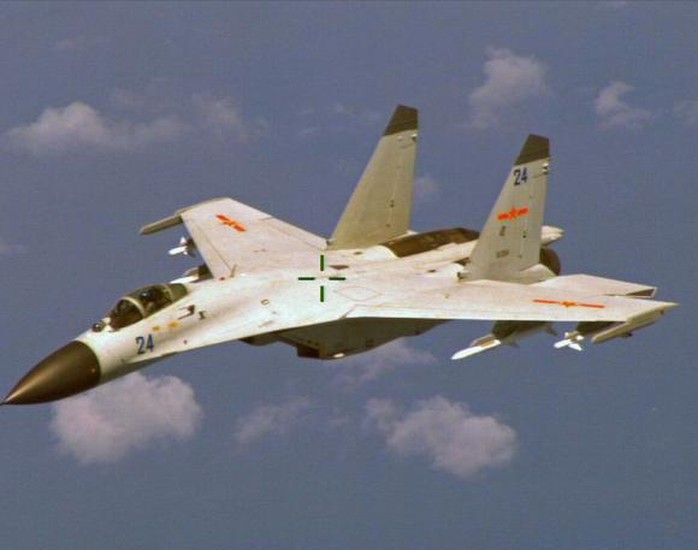 A Chinese J-11 fighter jet is seen flying near a U.S. Navy P-8 Poseidon about 215 km (135 miles) east of Chinas Hainan Island in this U.S. Department of Defense handout photo taken August 19, 2014.  REUTERS/U.S. Navy/Handout