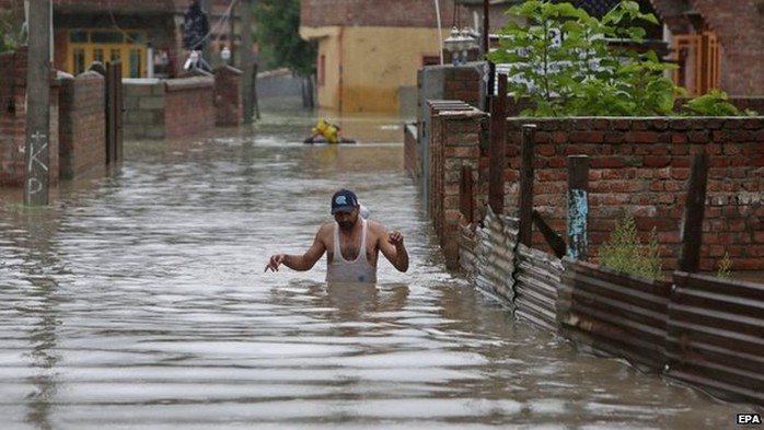 A Kashmiri man wades through flood water in the outskirts of Srinagar, the summer capital of Indian Kashmir on 04 September 2014.