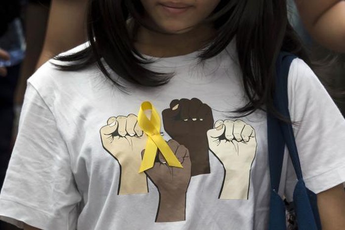 A secondary school student wears a yellow ribbon pinned to her T-shirt during a rally against Beijings election framework for Hong Kong, outside the government headquarters in Hong Kong September 26, 2014.   REUTERS-Tyrone Siu