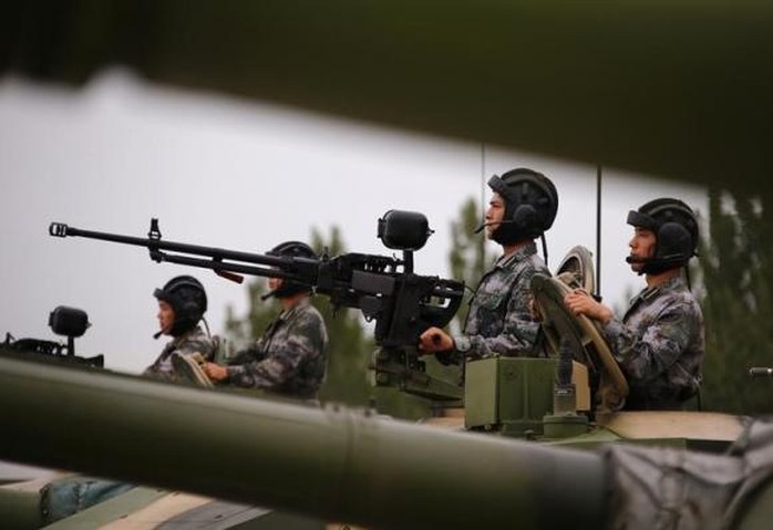 Soldiers of Peoples Liberation Army (PLA) stand inside tanks at a drill during an organised media tour at a PLA engineering academy in Beijing July 22, 2014. REUTERS/Petar Kujundzic