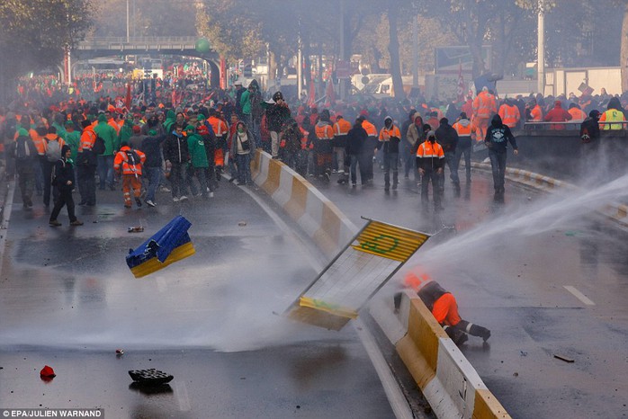 Provocative: Police fire water cannon at crowds of protesters at the end of a peaceful march through Brussels today