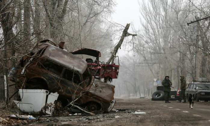 Pro-Russian separatists stand guard next to cars damaged during fighting between pro-Russian rebels and Ukrainian government forces near Donetsk Sergey Prokofiev International Airport, eastern Ukraine, December 16, 2014. REUTERS/Maxim Shemetov